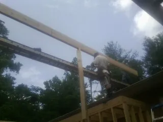 Carpenter setting a ridge beam over a new addition frame — Ice Dam Removal by Roofing Brothers in Bremerton