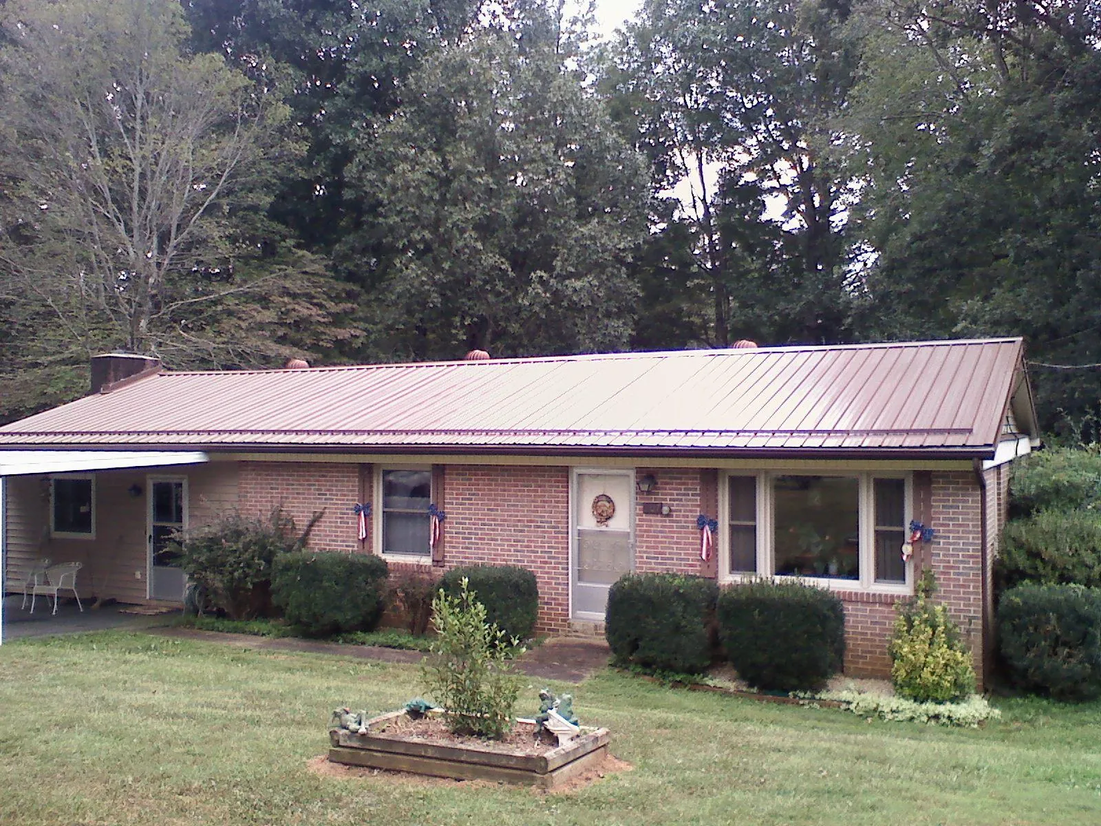 Bronze metal roof on a brick ranch home with a carport in Bremerton